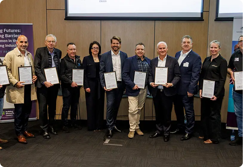 Group of people at a Building Futures event holding a framed document