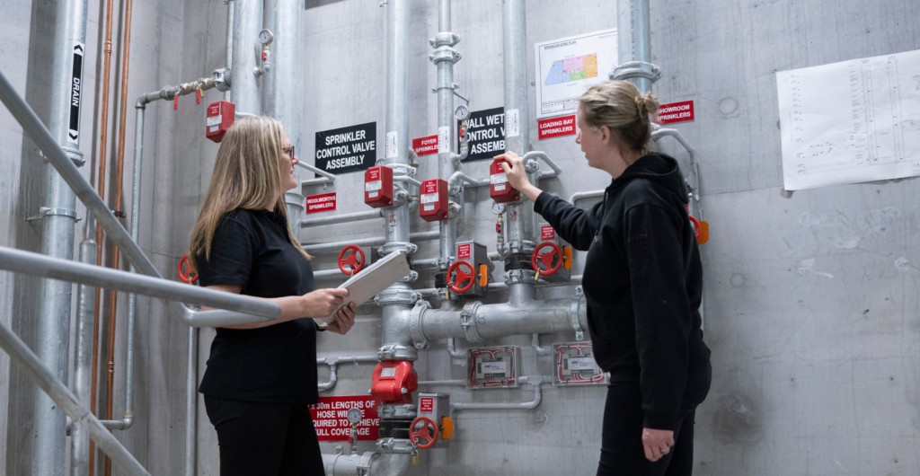Two women check the fire protection equipment for Leemark Fire Protection